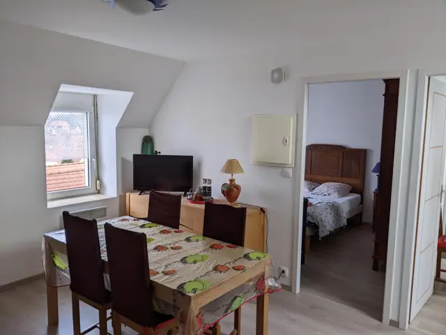 Séjour avec coin repas, chambre en arrière-plan