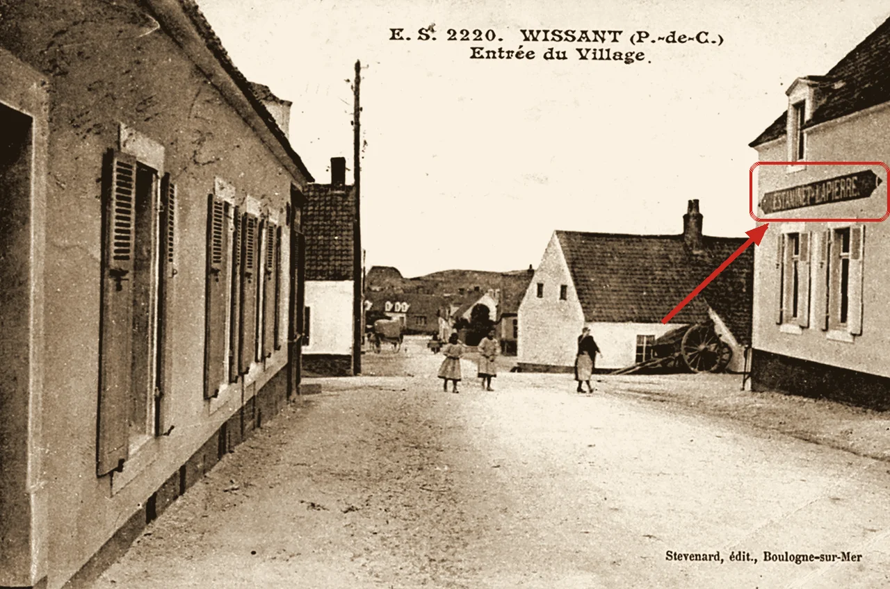 Carte postale ancienne de l'entrée de Wissant ; à droite, une flèche montre l'enseigne « Estaminet Lapierre » sur la façade