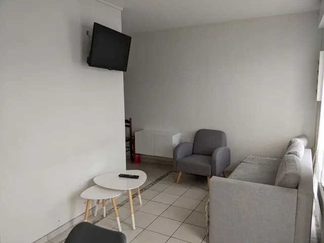 Salon avec canapé, fauteuil et télévision