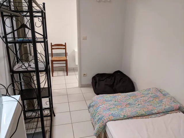 Chambre avec un lit d'une personne et une étagère