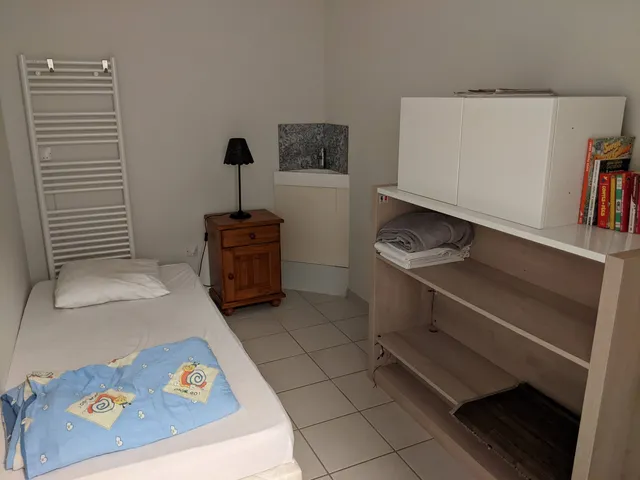 Chambre avec un lit d'une personne, lavabo et sèche-serviettes