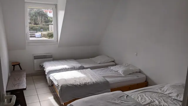 Chambre avec trois lits simples